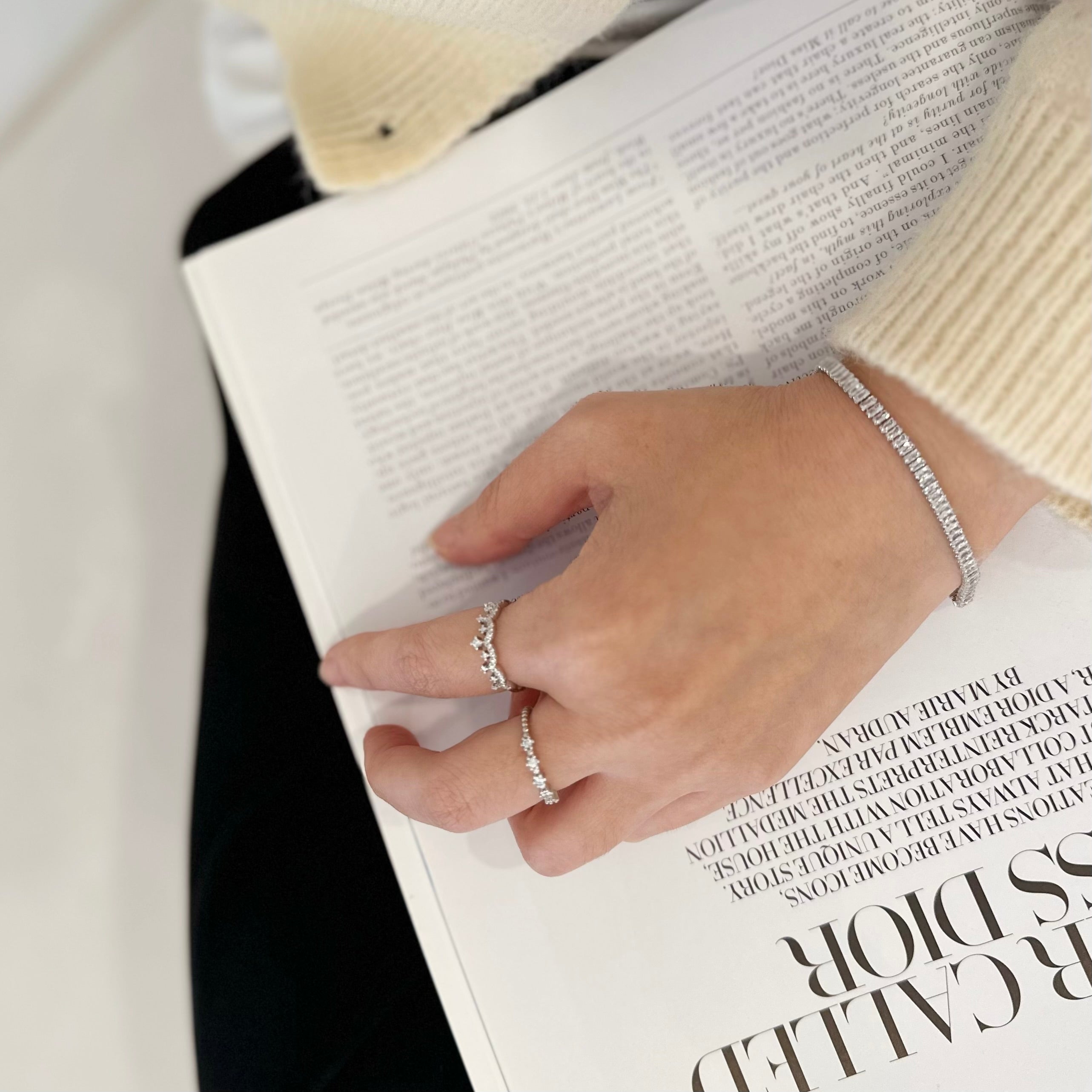 Hand with a ring and bracelet on a magazine