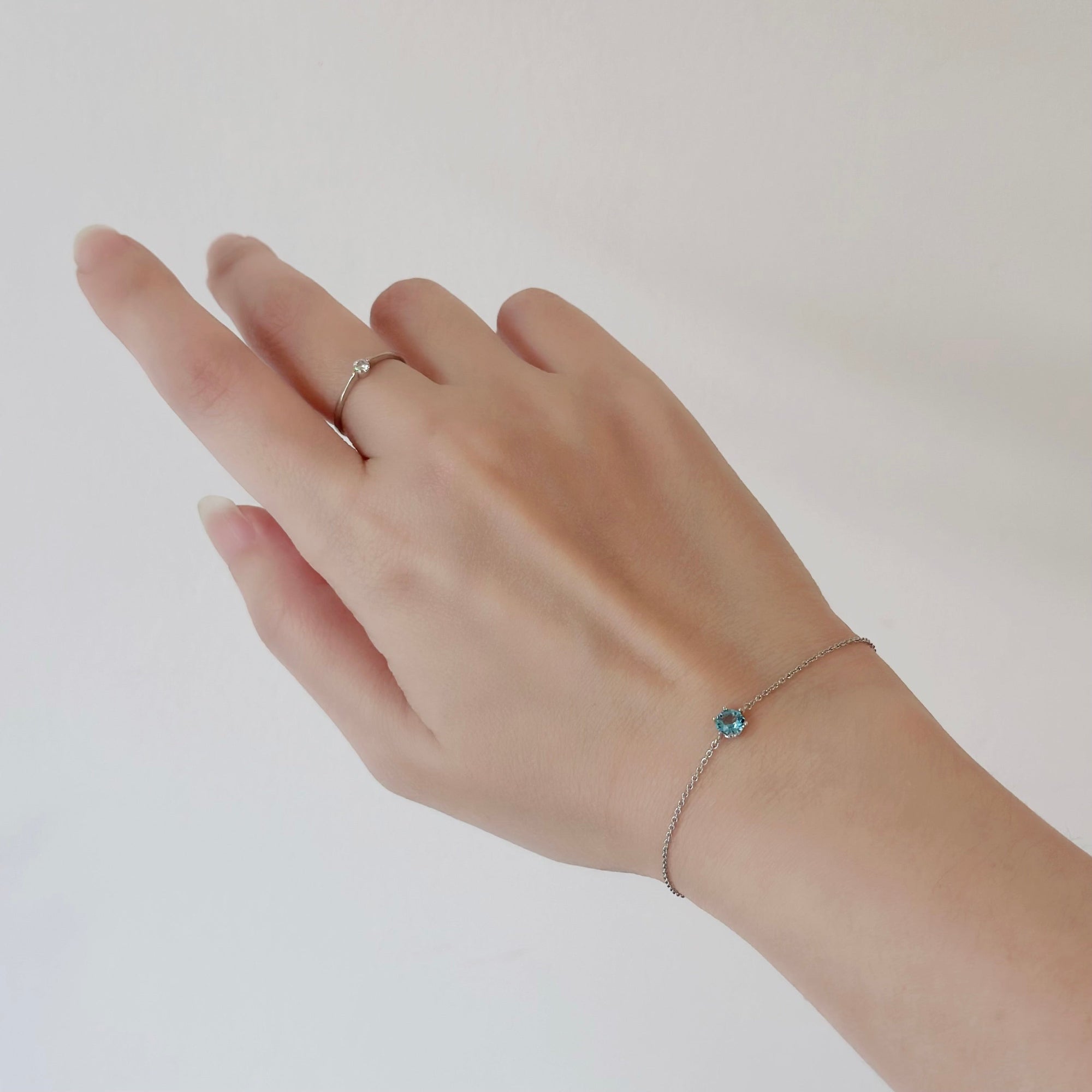 Hand wearing a silver ring and bracelet on a plain background, Gift set for her / hadiah untuk wanita / 送给她的礼物。Perfect for best friend / sahabat baik / 最好的朋友。Includes beloved earrings, bracelet, and ring / 心爱的耳环、手链和戒指。Made in Korea / 制造于韩国 / buatan Korea. Dainty jewellery / 简约精致首饰 / barang kemas halus. 925 sterling silver / 925纯银 / perak tulen 925. Anti-tarnish / 防氧化 / tahan karat. Suitable for daily wear / 适合日常佩戴 / sesuai untuk dipakai setiap hari/ blind box / plushie / toy / christmas